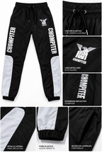 Detalles de los joggers CHOMPITER: cintura elástica con cordón, logo, estampado reflectivo, puños y bolsillos laterales